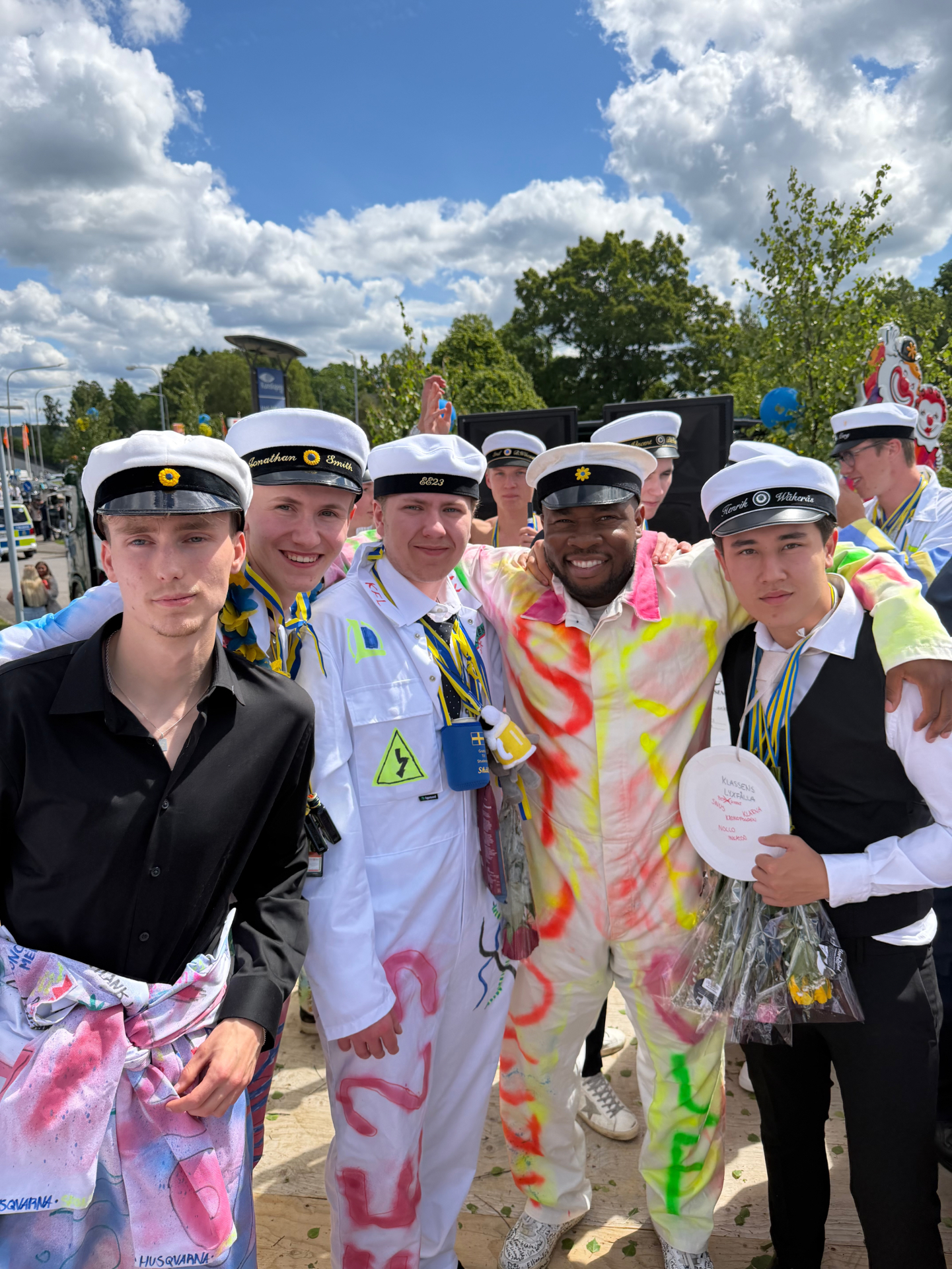 IKE tillsammans med studenter i studentmössor och studentoveraller